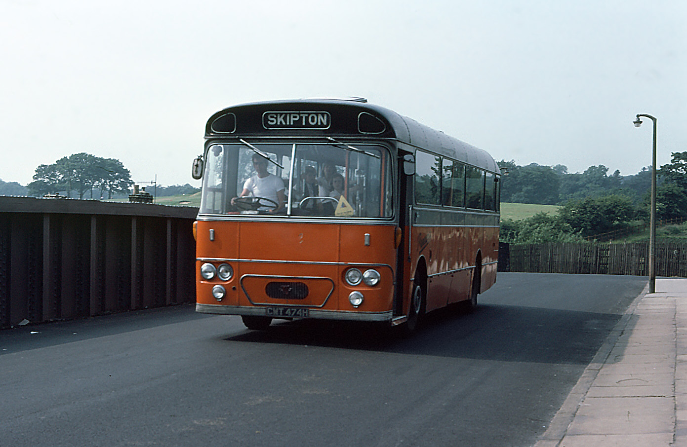 A school bus at a guarded railway crossing — the layered safety model this piece argues for.