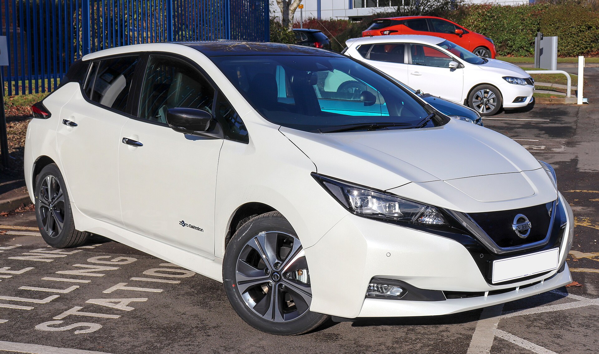 A 2018 Nissan Leaf parked at a charging station bay.