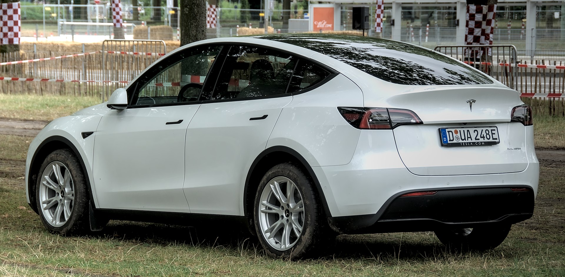 A Tesla Model Y, the kind of used EV whose owner must clear garage space to reach a 220-volt outlet for home charging.